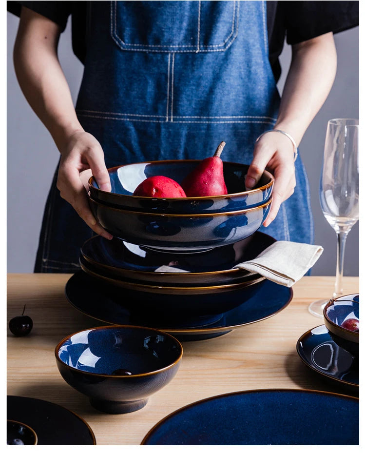 Deep blue ceramic dinnerware set by MC THE BLACK DIAMOND, includes plates and bowls with a sleek, modern design.