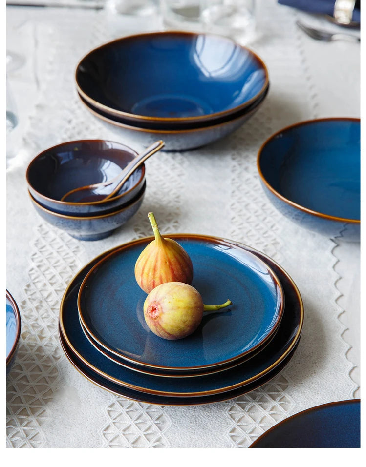 Deep blue ceramic dinnerware set by MC THE BLACK DIAMOND, includes plates and bowls with a sleek, modern design.