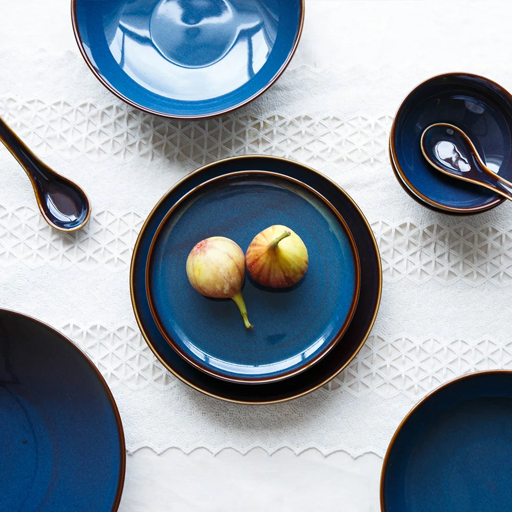 Deep blue ceramic dinnerware set by MC THE BLACK DIAMOND featuring plates, bowls, and cups on a table setting.