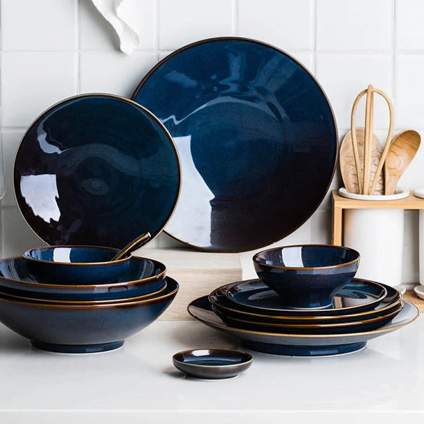 Deep blue ceramic dinnerware set by MC THE BLACK DIAMOND, includes plates and bowls with a sleek, modern design.