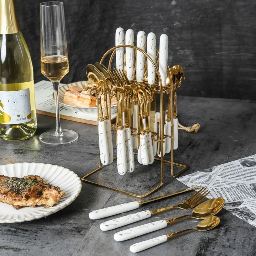 Stainless steel flatware set by MC THE BLACK DIAMOND with forks, knives, and spoons arranged on a table.