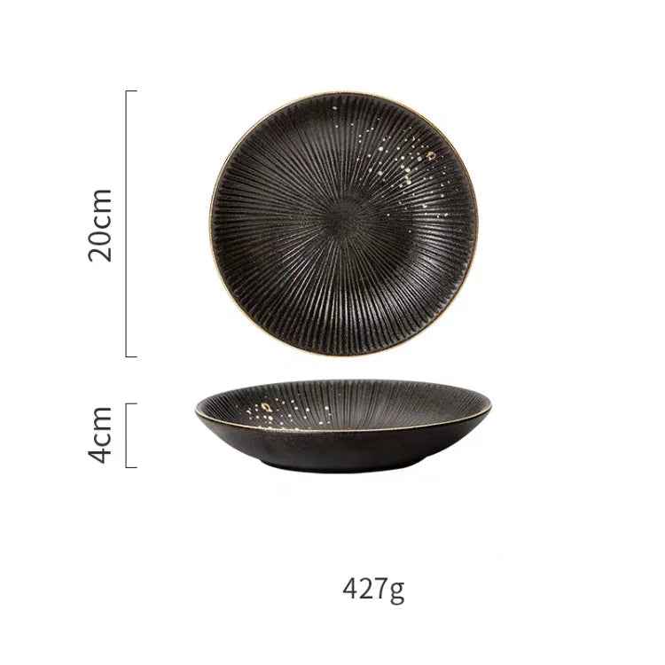 Luxury golden and black dinnerware set by MC THE BLACK DIAMOND, featuring elegant plates and bowls on a sleek table.