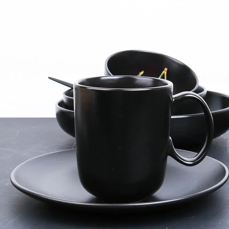 Deep black MC THE BLACK DIAMOND family dinner set with plates, bowls, and mugs arranged on a dining table.