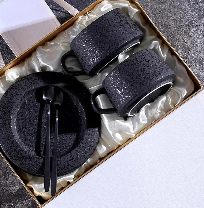 Black ceramic coffee cup and saucer set with spoon and cup holder, part of MC THE BLACK DIAMOND coffee and tea sets.