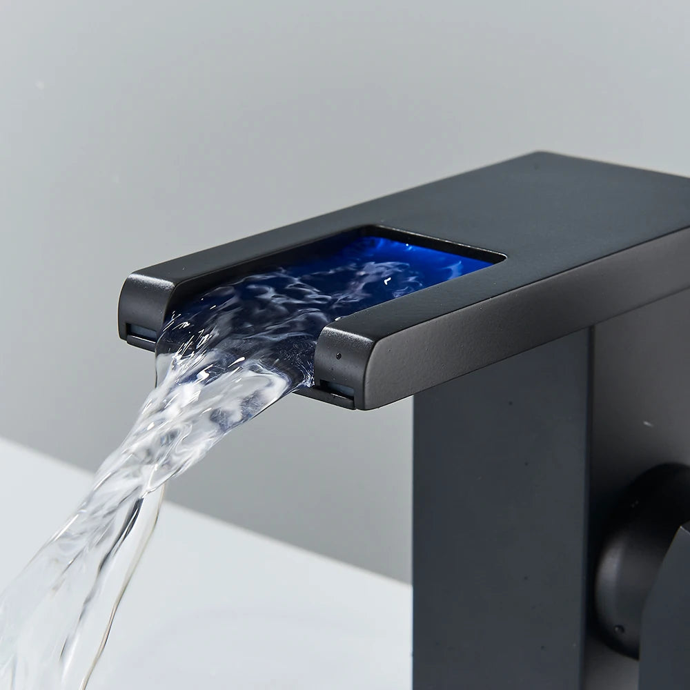Black LED bathroom sink faucet by MC THE BLACK DIAMOND, brass waterfall mixer with hot and cold water controls.