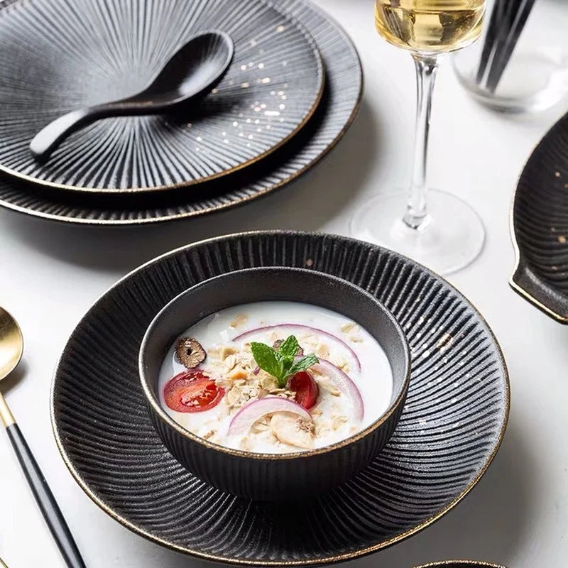 Luxury golden and black dinnerware set by MC THE BLACK DIAMOND, featuring elegant plates and bowls for sophisticated table settings.