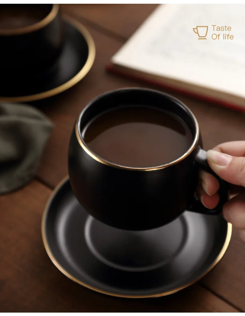 Creative matte black ceramic coffee cup with gold border and matching saucer, modern design for cafe or home use.