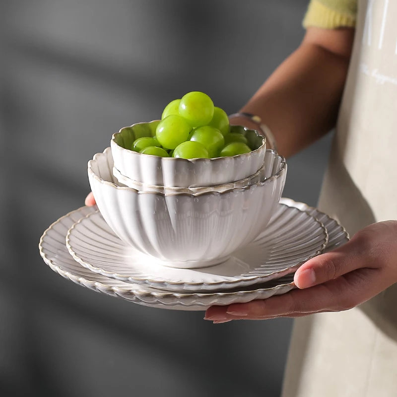 White chrysanthemum-shaped ceramic dinnerware set by MC THE BLACK DIAMOND, featuring elegant plates and bowls with floral design.