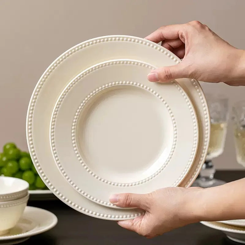 Modern minimalist ceramic dinnerware set by MC THE BLACK DIAMOND, round plates and bowls arranged on a table.
