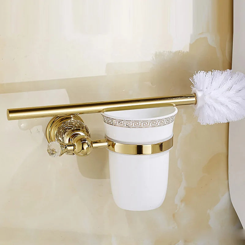Luxury gold polished brass bathroom accessories set by MC THE BLACK DIAMOND, including soap dispenser, toothbrush holder, and tumbler.