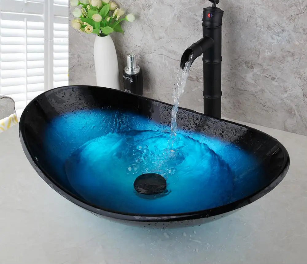 Blue glass vessel sink and waterfall faucet set by MC THE BLACK DIAMOND, modern bathroom vanity with sleek glass and chrome fixtures.