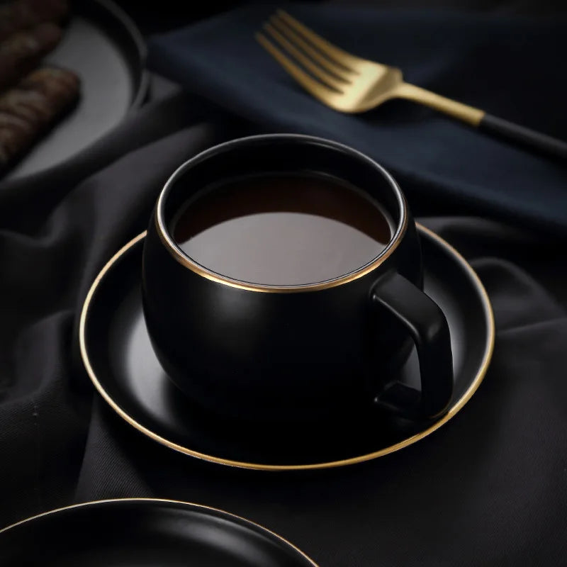 Creative matte black ceramic coffee cup with gold border and matching saucer, modern design from 𝕄𝕔 𝕋𝕙𝕖 𝔹𝕝𝕒𝕔𝕜 𝔻𝕚𝕒