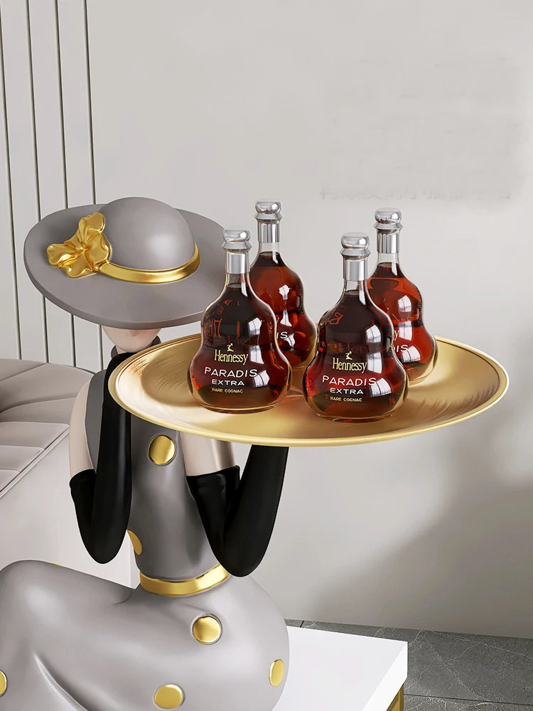 Decorative figurines on MC THE BLACK DIAMOND tray in a living room foyer next to TV cabinet and sofa, stylish home decor display