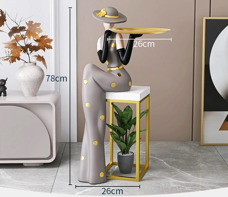 Decorative tray with figurines from MC THE BLACK DIAMOND, placed on a living room foyer TV cabinet next to the sofa.