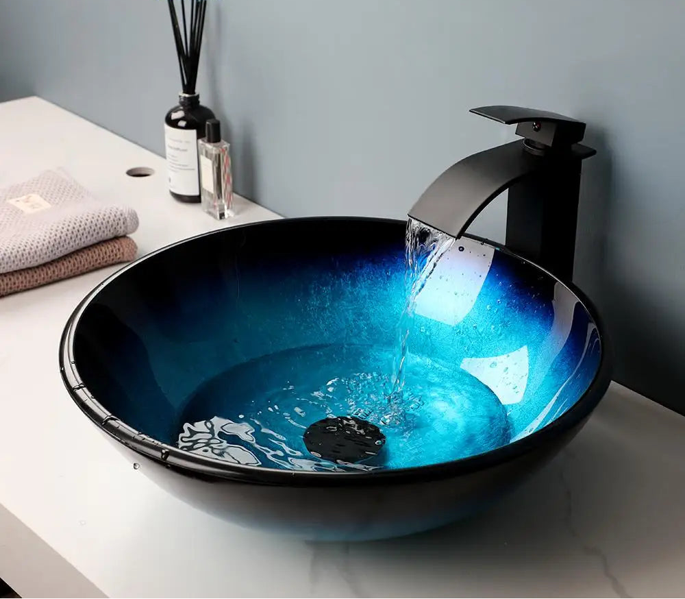 Blue glass vessel sink with waterfall faucet set by MC THE BLACK DIAMOND, showcasing sleek glass design and modern faucet features.
