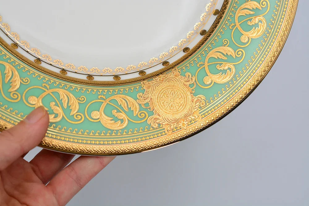 Embro embossed gold porcelain dinnerware set by MC THE BLACK DIAMOND, featuring elegant plates and bowls with intricate gold detailing.