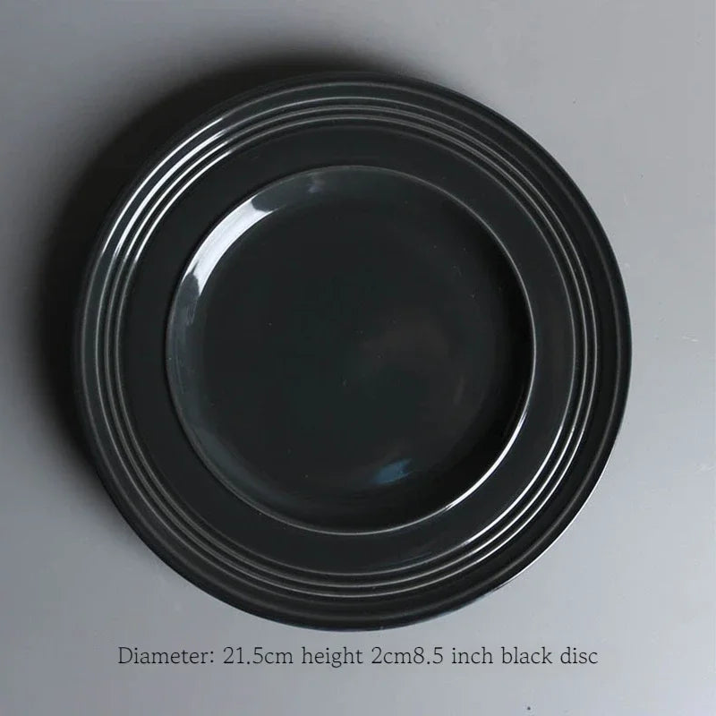 Deep black dinnerware set by MC THE BLACK DIAMOND, featuring plates, bowls, and mugs for family dining.