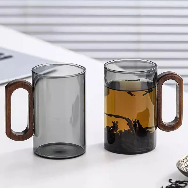 Glass mug with wooden handle from MC THE BLACK DIAMOND drinkware set, designed for hot beverages, featuring a clear glass body and wooden grip.