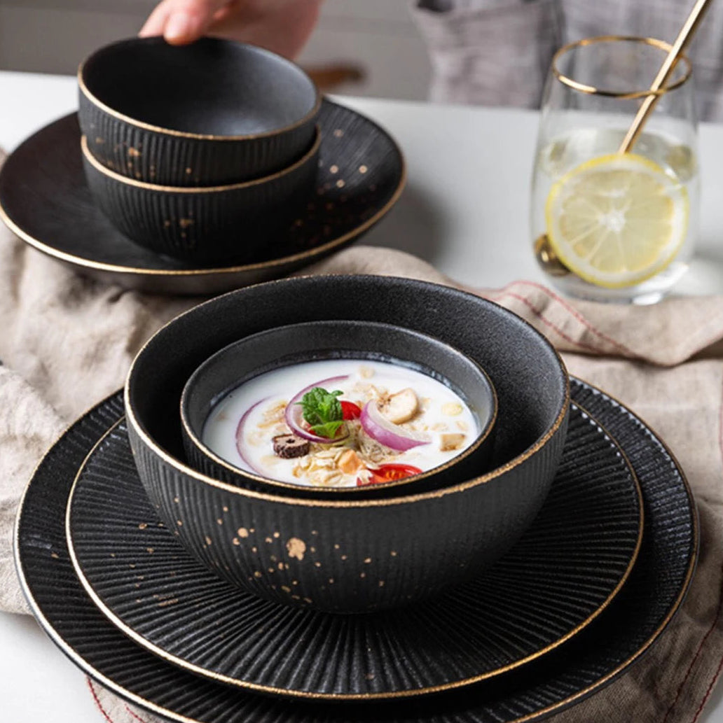 Luxury golden and black dinnerware set by MC THE BLACK DIAMOND, elegant tableware with intricate design details.