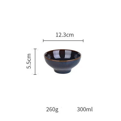 Deep blue ceramic dinnerware set by MC THE BLACK DIAMOND, includes plates, bowls, and cups arranged on a table.