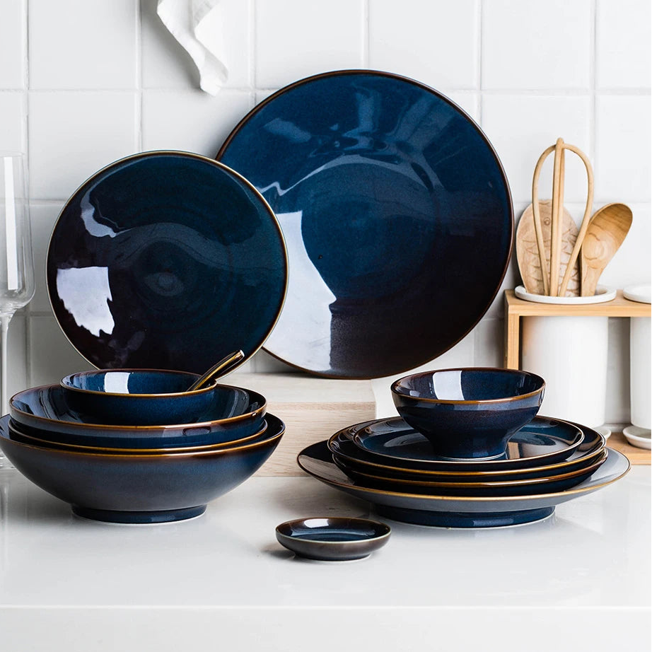 Deep blue ceramic dinnerware set by MC THE BLACK DIAMOND with matching plates and bowls, elegant and modern tableware for dining.