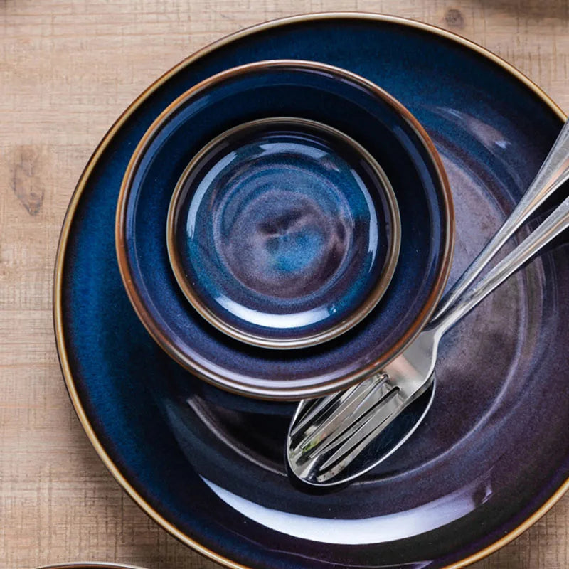 Deep blue ceramic dinnerware set by MC THE BLACK DIAMOND, includes plates and bowls with a sleek, glossy finish.
