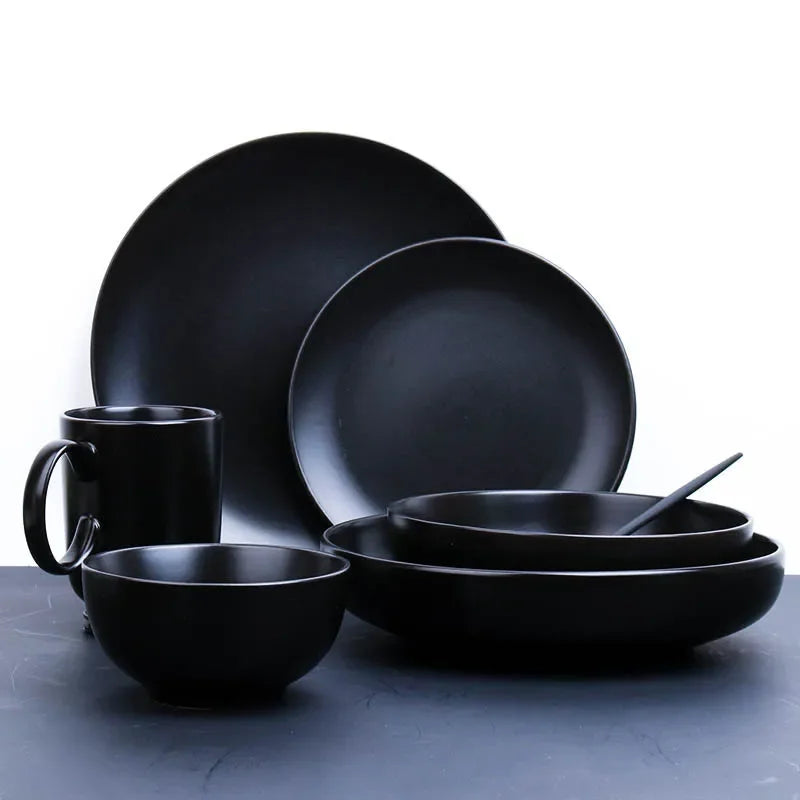 Deep black MC THE BLACK DIAMOND family dinner set with plates, bowls, and cups arranged on a dining table.