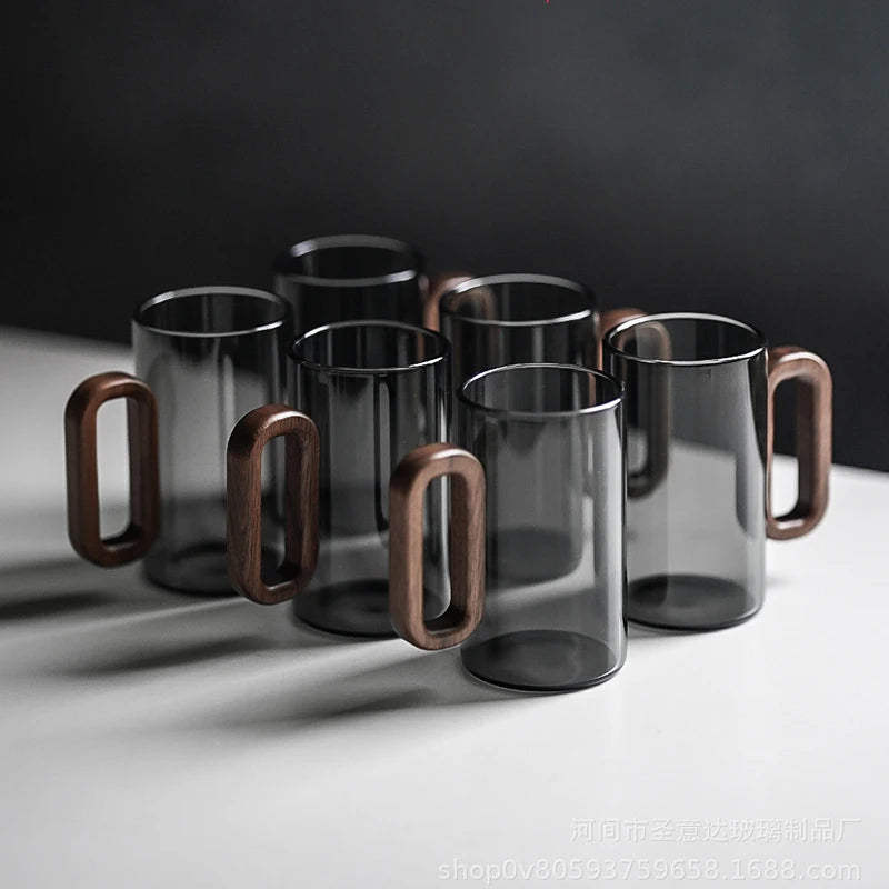 Glass mug with wooden handle from MC The Black Diamond drinkware set, showcasing a modern design and clear glass with a wooden grip.