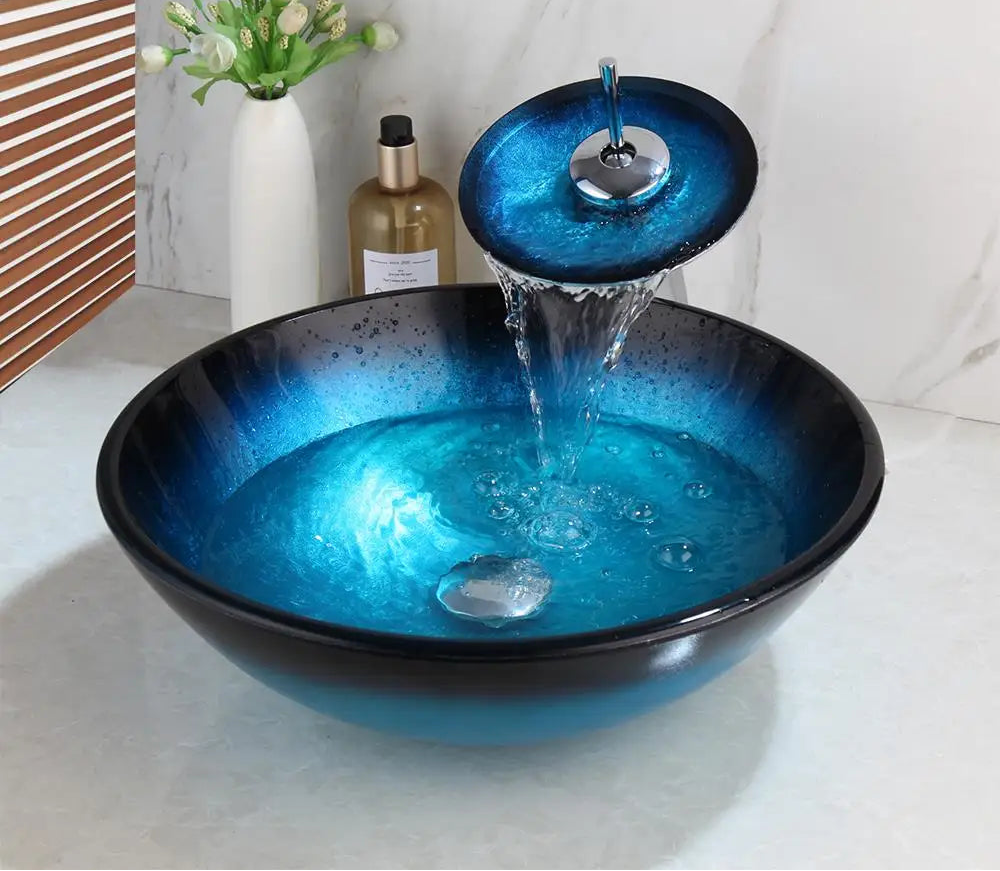 Blue glass vessel sink with waterfall faucet set by MC THE BLACK DIAMOND, showcasing sleek ceramic basin and modern water feature.