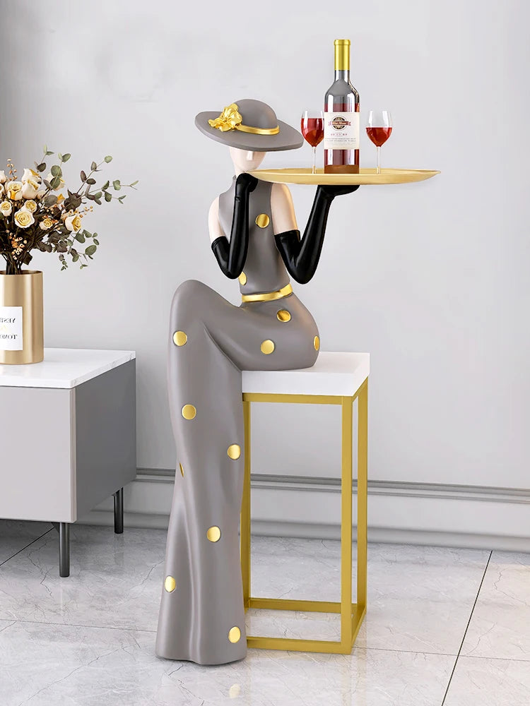 Decorative figurines on MC THE BLACK DIAMOND tray in a living room foyer next to a TV cabinet and sofa.