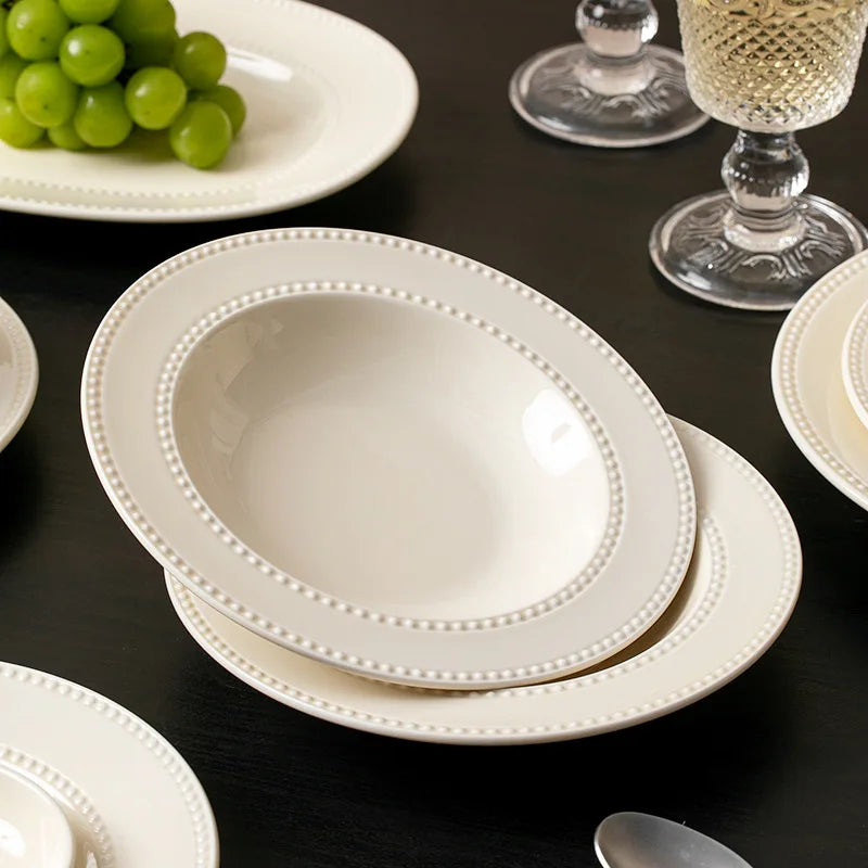 Set of modern minimalist ceramic round dinnerware by MC THE BLACK DIAMOND, featuring plates and bowls arranged on a table.