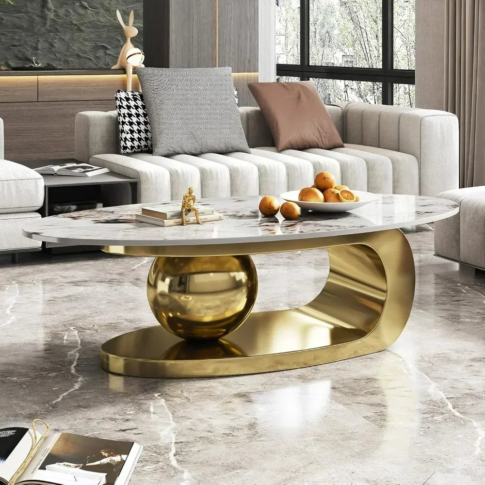 Modern oval stone coffee table with abstract gold metal base in stylish living room setting, 51 inches long by 16.5 inches high.