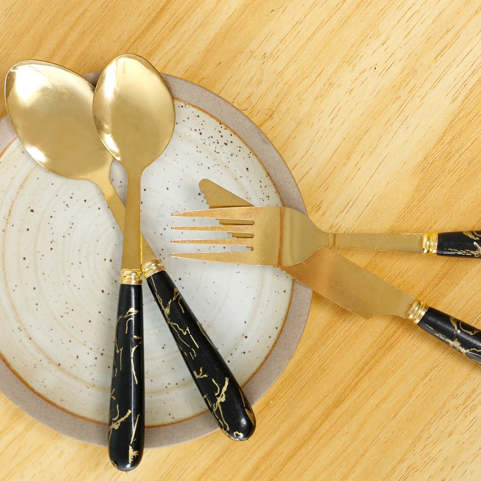 Stainless steel flatware set with holder from MC THE BLACK DIAMOND, including spoons, forks, and knives arranged in the holder.