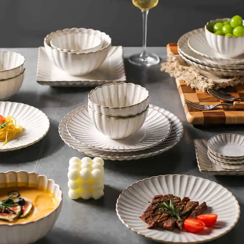 White chrysanthemum-shaped ceramic dinnerware set by MC THE BLACK DIAMOND, featuring elegant floral design and matching dinner plates and bowls.