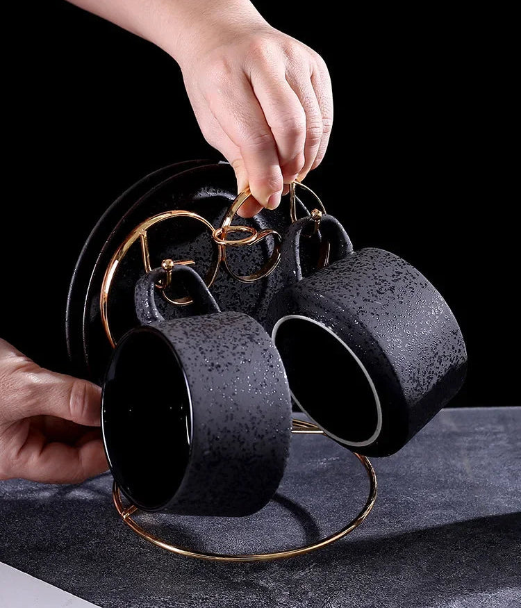 Black ceramic coffee cup with matching saucer, spoon, and cup holder from MC THE BLACK DIAMOND coffee and tea set.