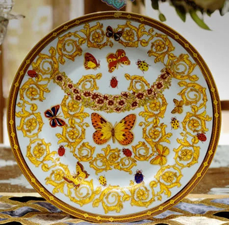 MC THE BLACK DIAMOND Golden Butterfly dinnerware set featuring elegant plates and bowls with butterfly motifs.