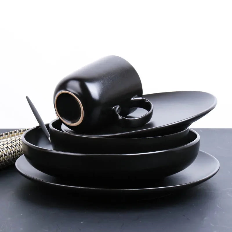 Deep black family dinnerware set by MC THE BLACK DIAMOND, featuring plates and bowls arranged for a family meal.
