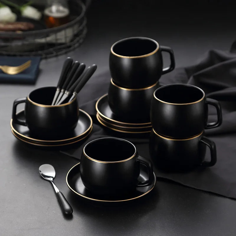 Matte black ceramic coffee cup with gold border and matching saucer, modern design from 𝕄𝕔 𝕋𝕙𝕖 𝔹𝕝𝕒𝕔𝕜 𝔻𝕚𝕒