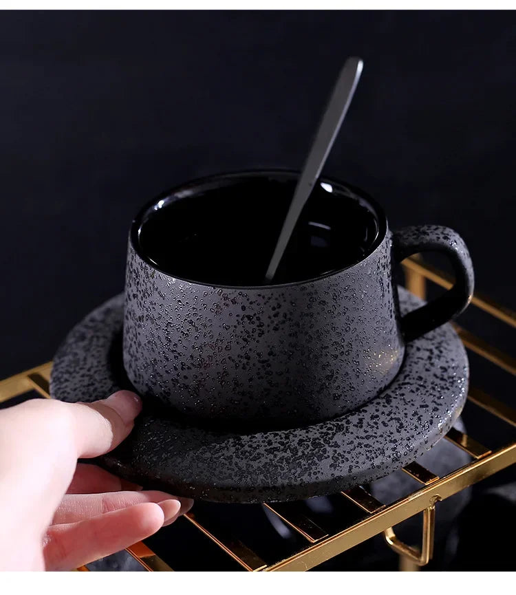 Black ceramic coffee cup and saucer set with black spoon and cup holder, part of MC THE BLACK DIAMOND coffee and tea sets.
