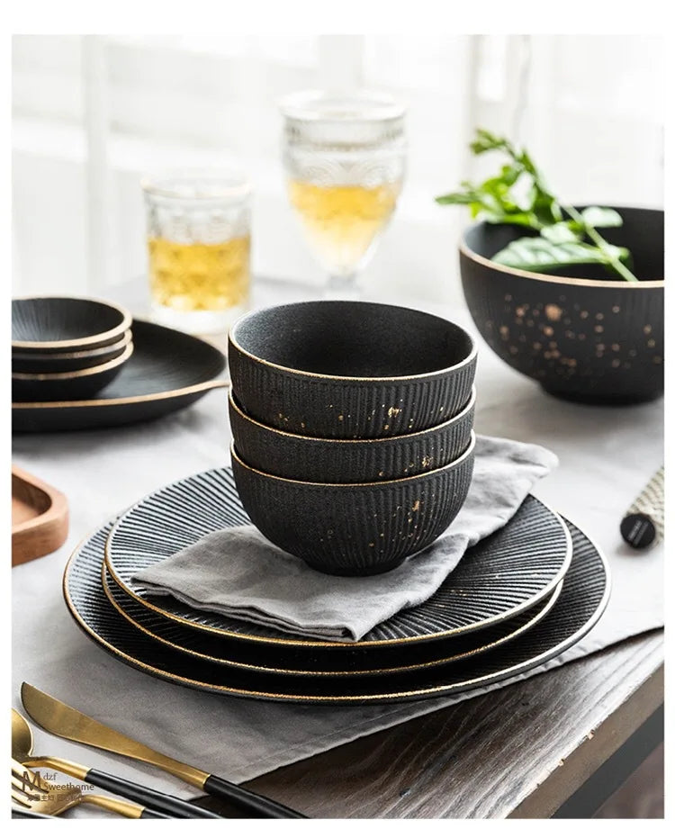 Luxury Golden Black dinnerware set by MC THE BLACK DIAMOND, elegant black and gold ceramic plates and bowls arranged on a table.