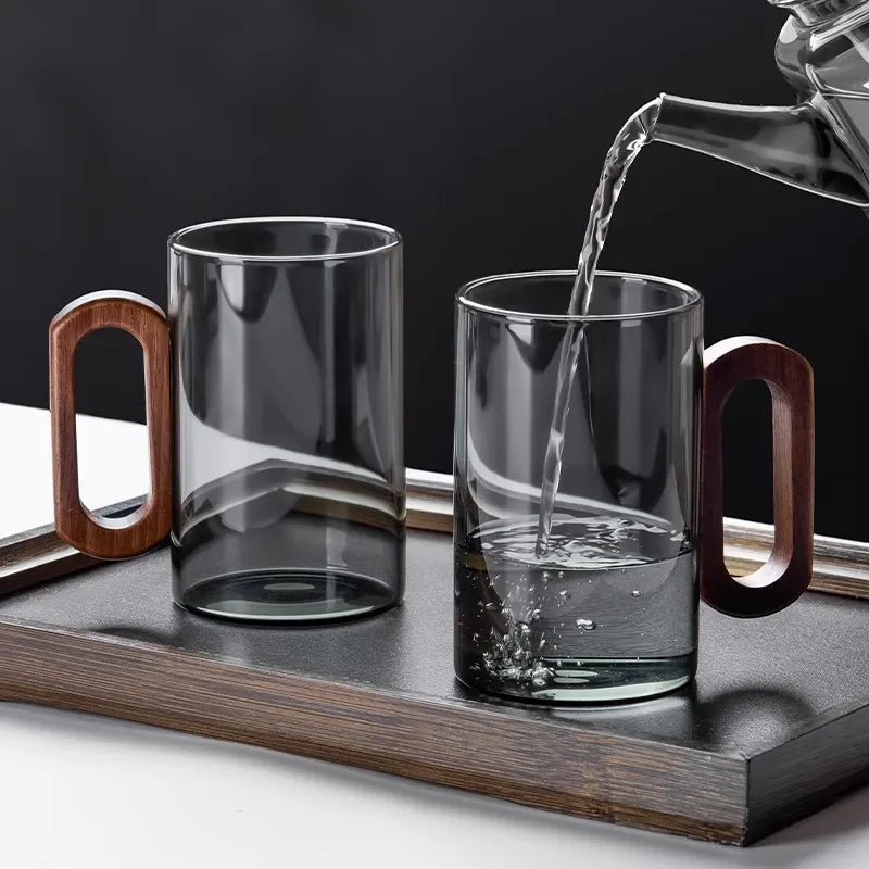 Glass mug with wooden handle from MC THE BLACK DIAMOND drinkware set, perfect for hot beverages, showcasing clear glass and natural wood handle.