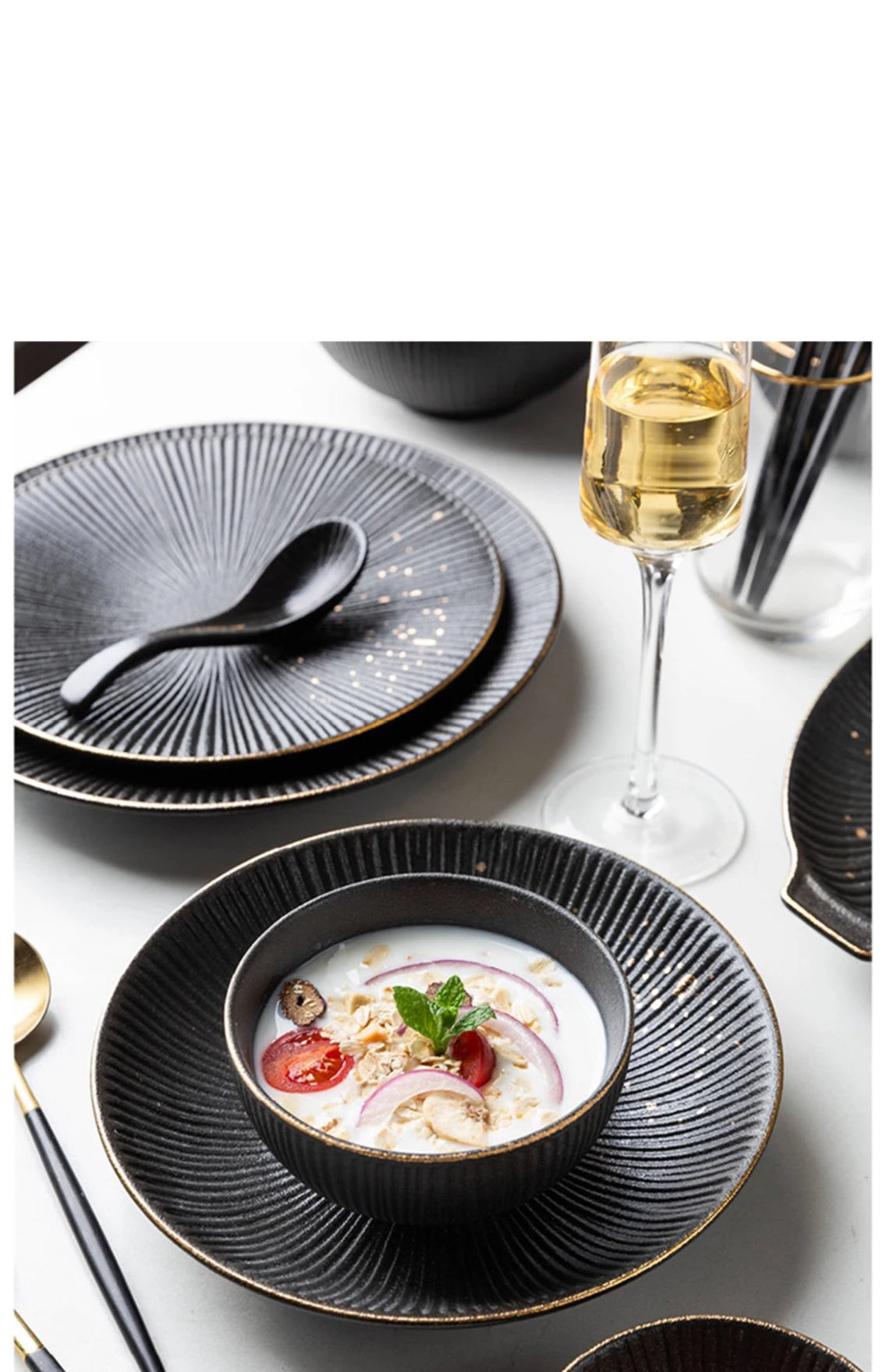 Elegant black and gold dinnerware set by MC THE BLACK DIAMOND featuring plates and bowls for luxurious table settings.