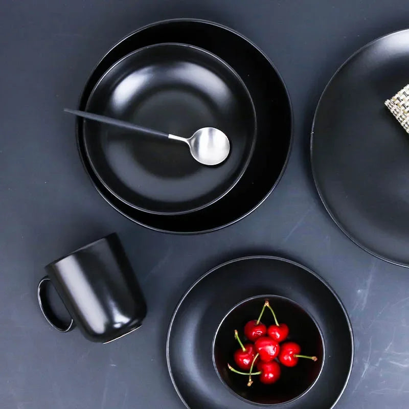 Deep black MC THE BLACK DIAMOND family dinner set with plates, bowls, and cups arranged on a dining table.