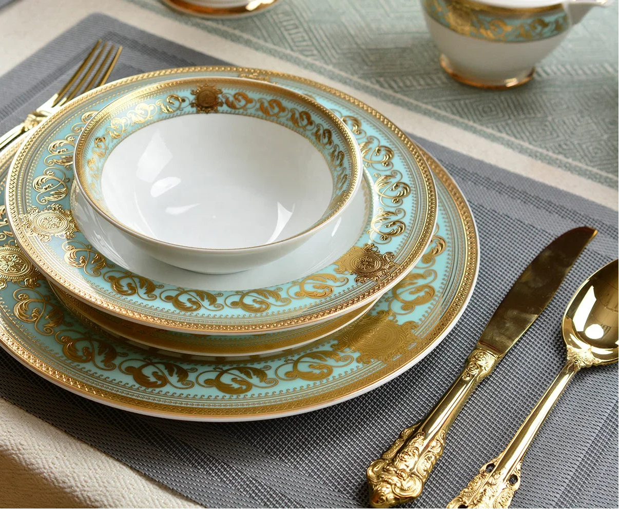 Embossed gold porcelain dinnerware set by MC THE BLACK DIAMOND, featuring elegant plates and bowls with intricate gold embossed designs.