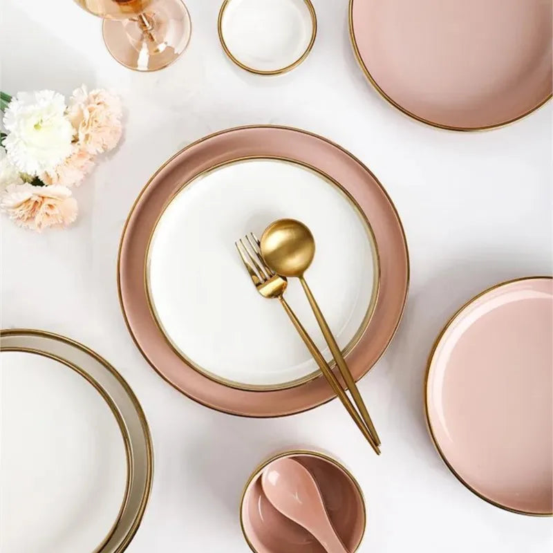 Set of bright white and pink porcelain plates with gold accents, by MC THE BLACK DIAMOND, for elegant kitchen table settings.