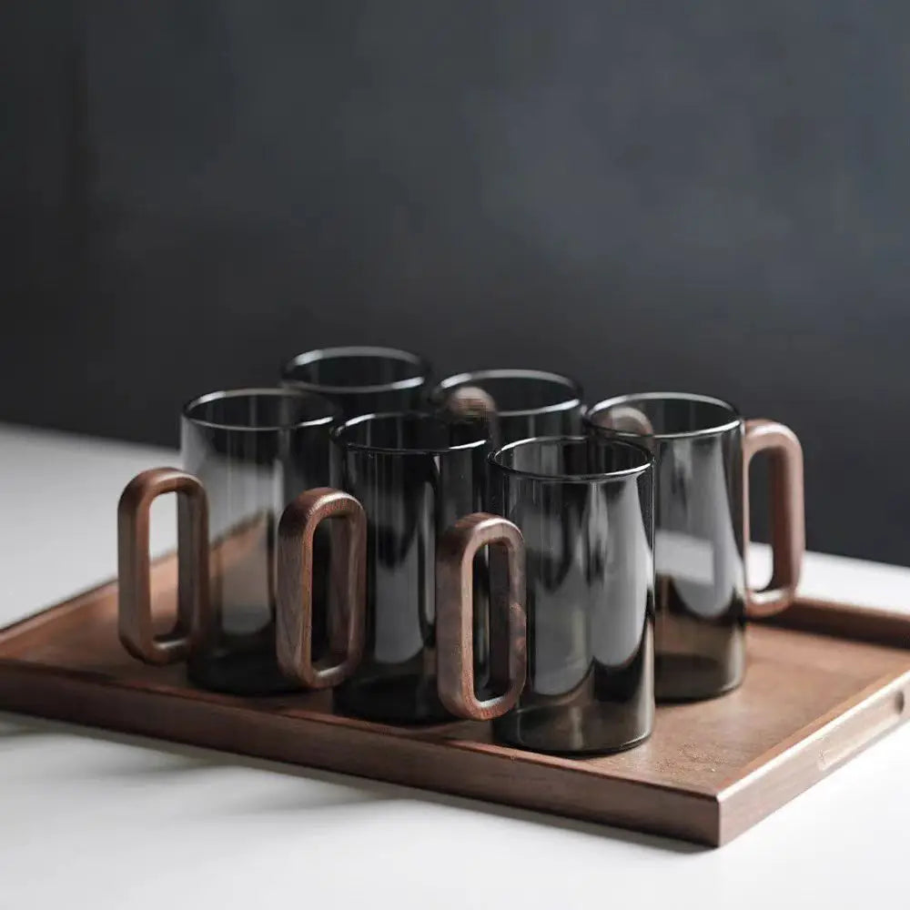 Glass mug with wooden handle from MC THE BLACK DIAMOND drinkware set, designed for hot beverages.