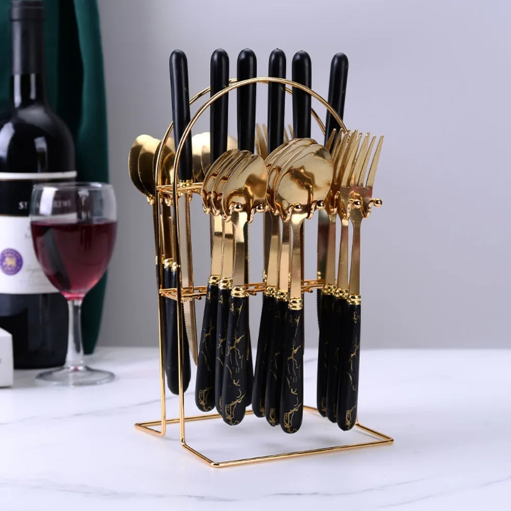 Stainless steel flatware set by MC THE BLACK DIAMOND, including forks, knives, and spoons arranged on a table.