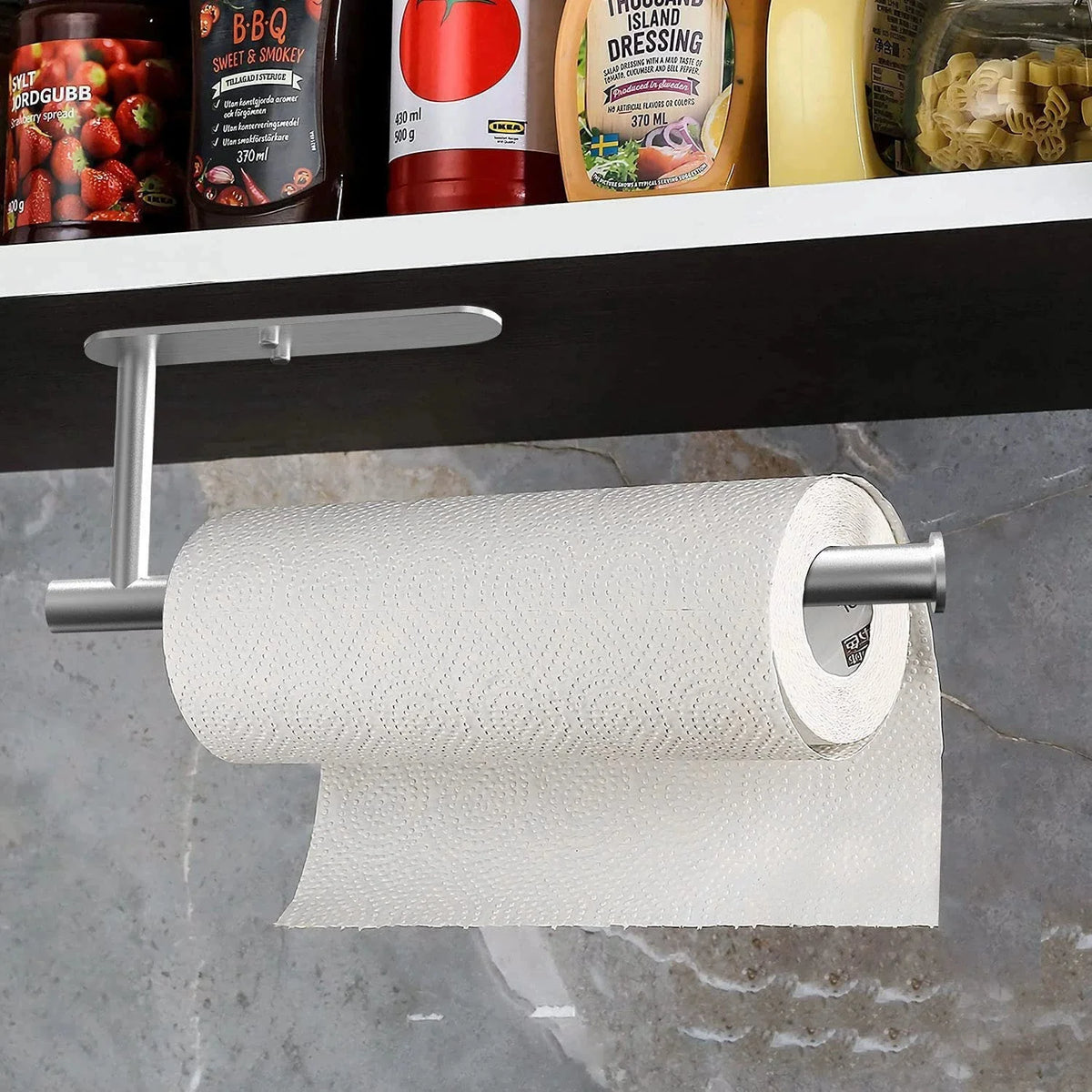 Self-adhesive paper towel holder for under cabinet kitchen use, branded MC THE BLACK DIAMOND, shown installed beneath a cabinet.