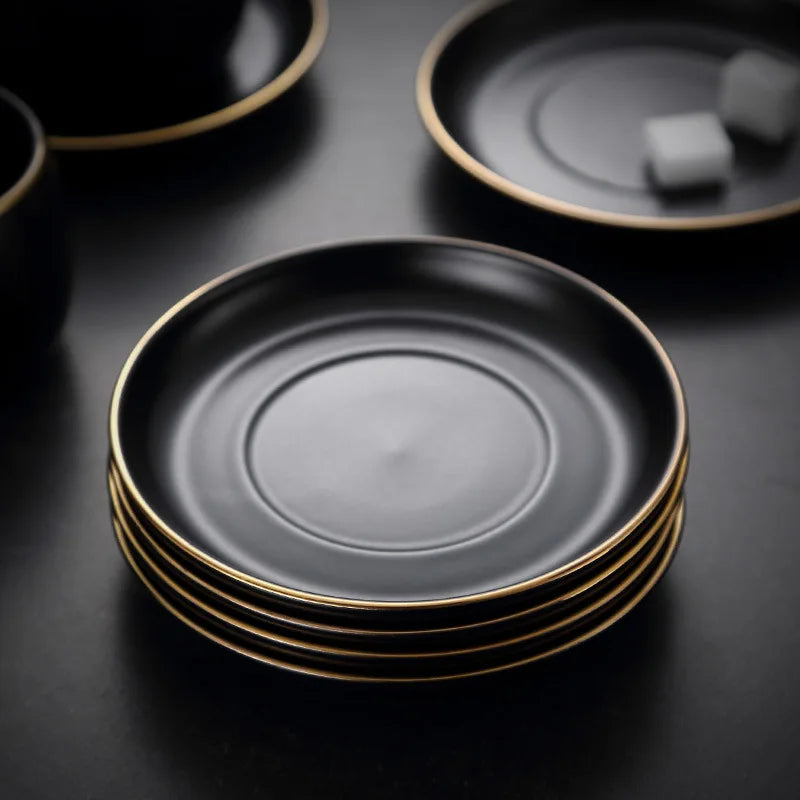 Creative matte black ceramic coffee cup with gold border and matching saucer, modern design for cafe or home use.