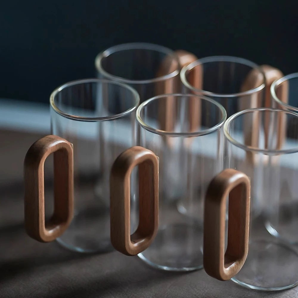 Glass mug with wooden handle from MC The Black Diamond drinkware set, featuring a clear glass design and sturdy wooden handle.